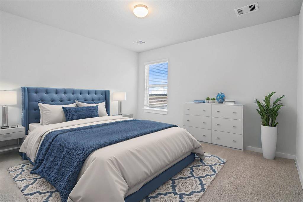 Secondary bedroom features plush carpet, custom paint and a large window with privacy blinds.