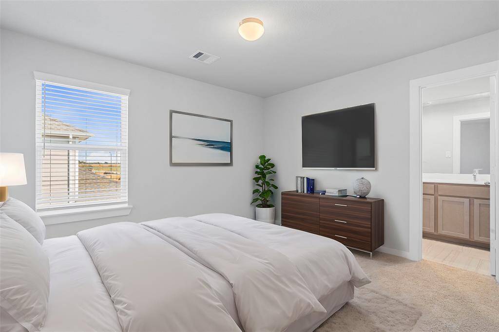 Secondary bedroom features plush carpet, custom paint, high ceilings, large window with privacy blinds, and its own private access to a secondary bathroom.