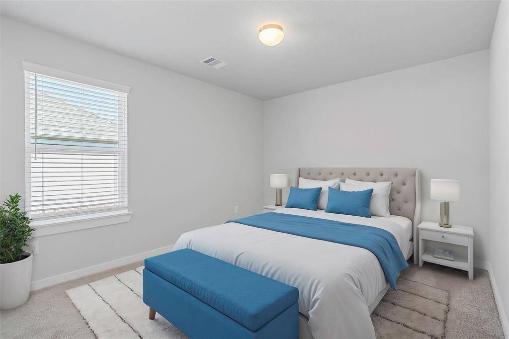 Secondary bedroom features plush carpet, custom paint, high ceilings, and a large window with privacy blinds.