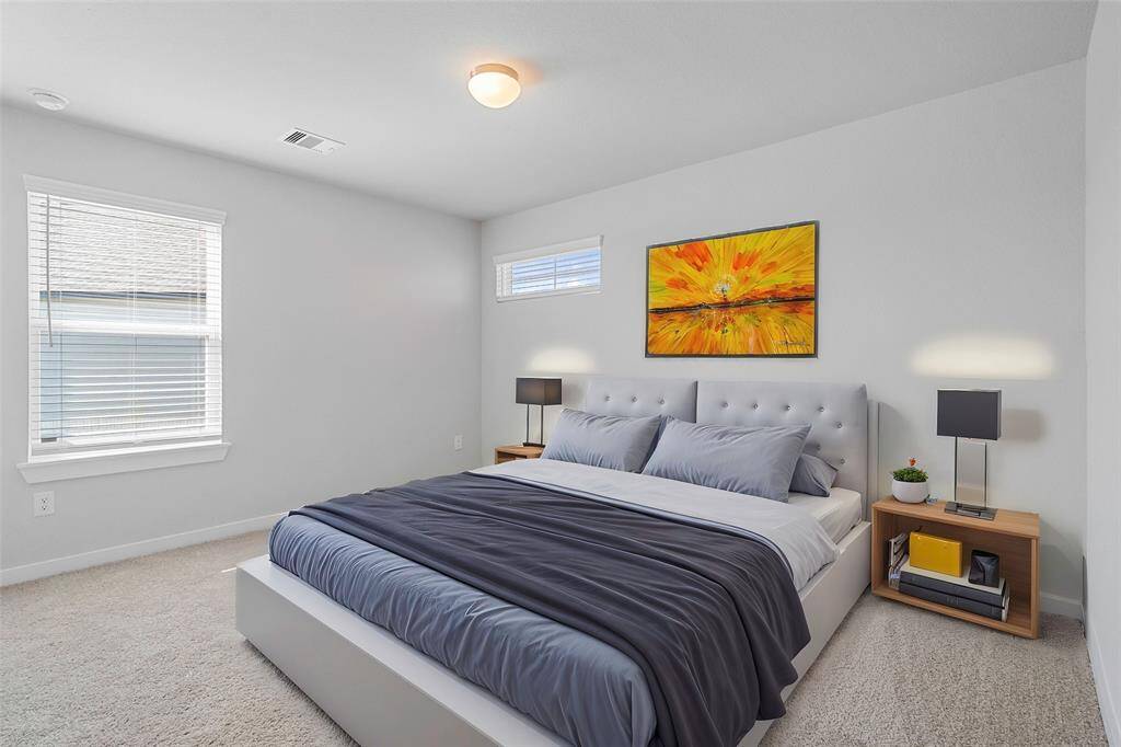 Secondary bedroom features plush carpet, custom paint, high ceilings, and a large window with privacy blinds.