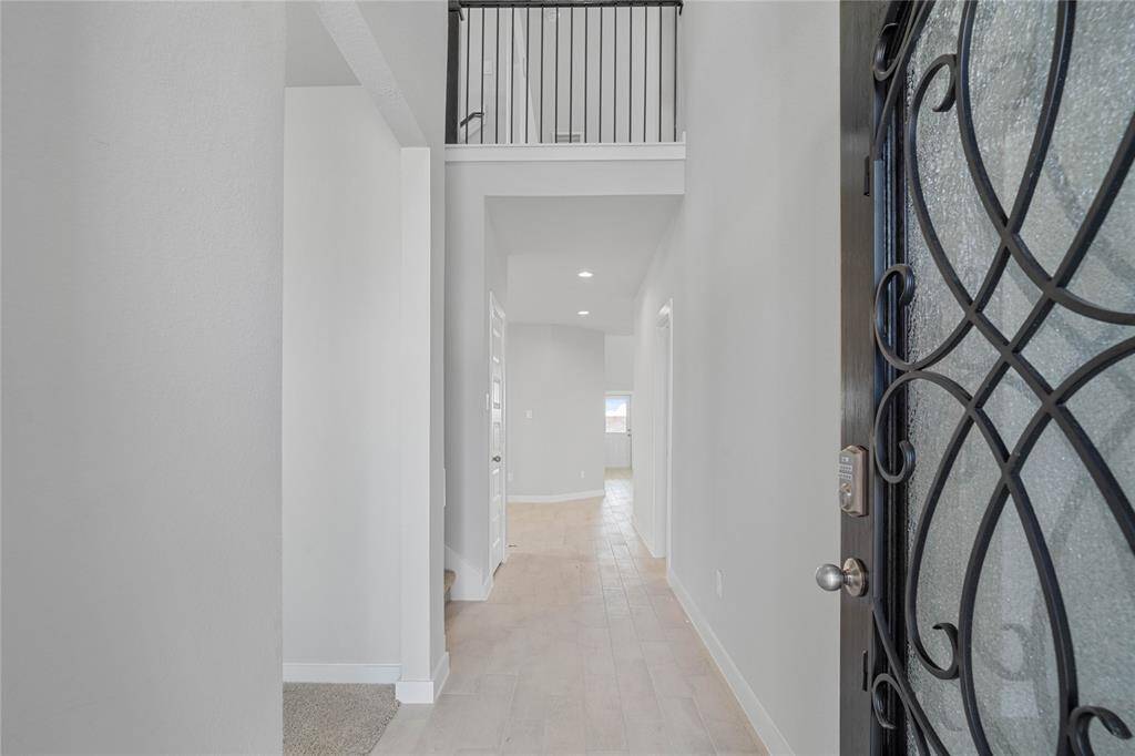 Welcome to your new home at 317 West Tranquil Fields Lane. This entryway greets you with an ornate front door, beautiful tile flooring, custom paint, and recessed lighting.
