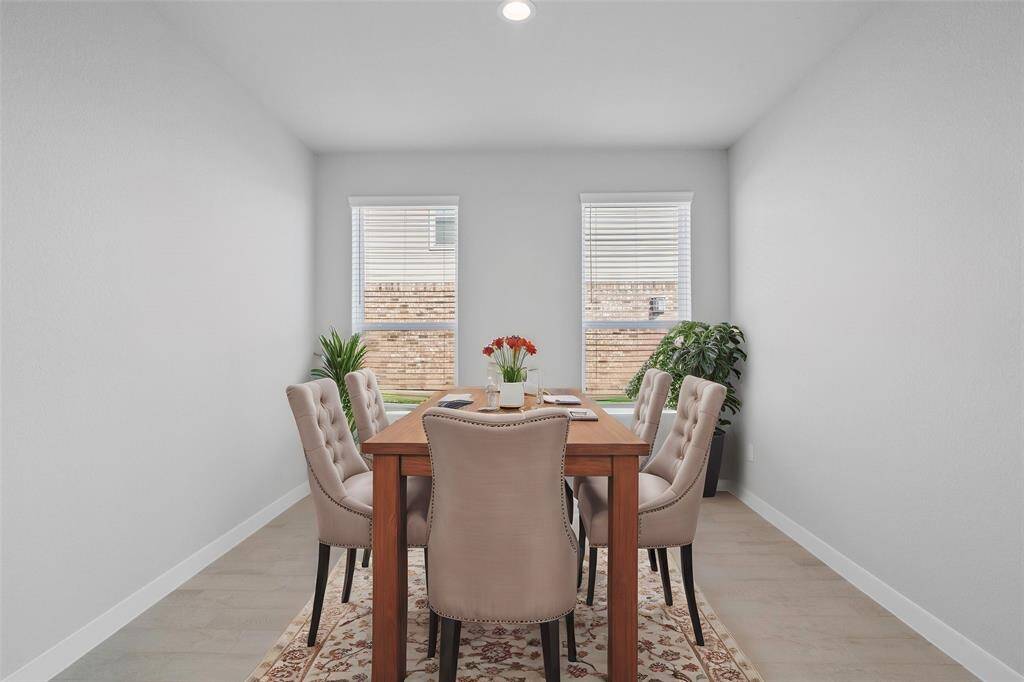 You and your guests will certainly dine in style in this amazing formal dining room! Featuring large windows with blinds, neutral paint, high ceilings, and tile flooring! Perfect space to entertain family and friends!