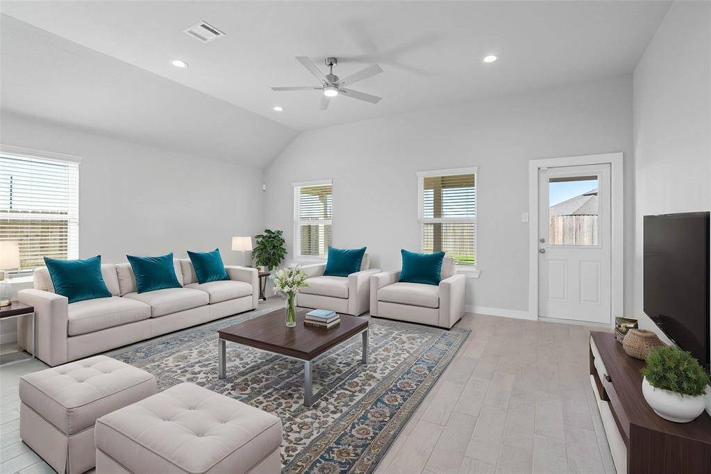 This light and bright spacious family room is the perfect layout for entertaining or just relaxing! Whether it's simply a night in or entertaining family and friends, this home has ample open space for everyone to enjoy! Featuring high ceilings with ceiling fan, wood look tile flooring, large windows with blinds, recessed lighting with wonderful access to your gorgeous kitchen!