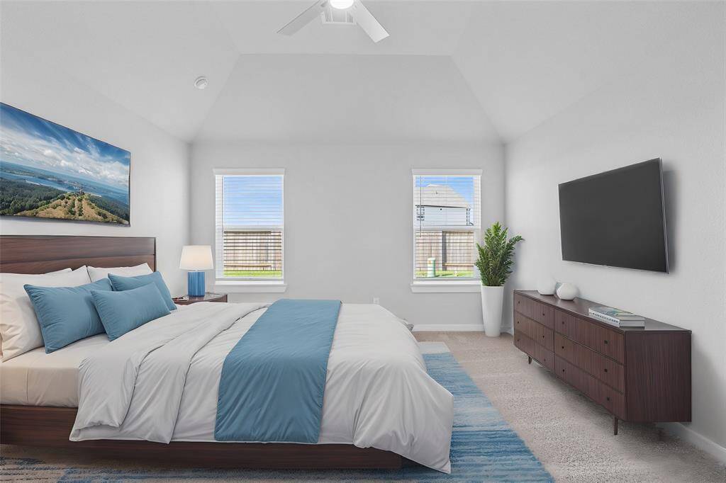 What a wonderful place to come home to, this stunning primary suite greets you with plush carpet flooring, warm custom paint, high ceiling with ceiling fan, large windows with blinds allowing in natural light brightening up this spacious primary bedroom.