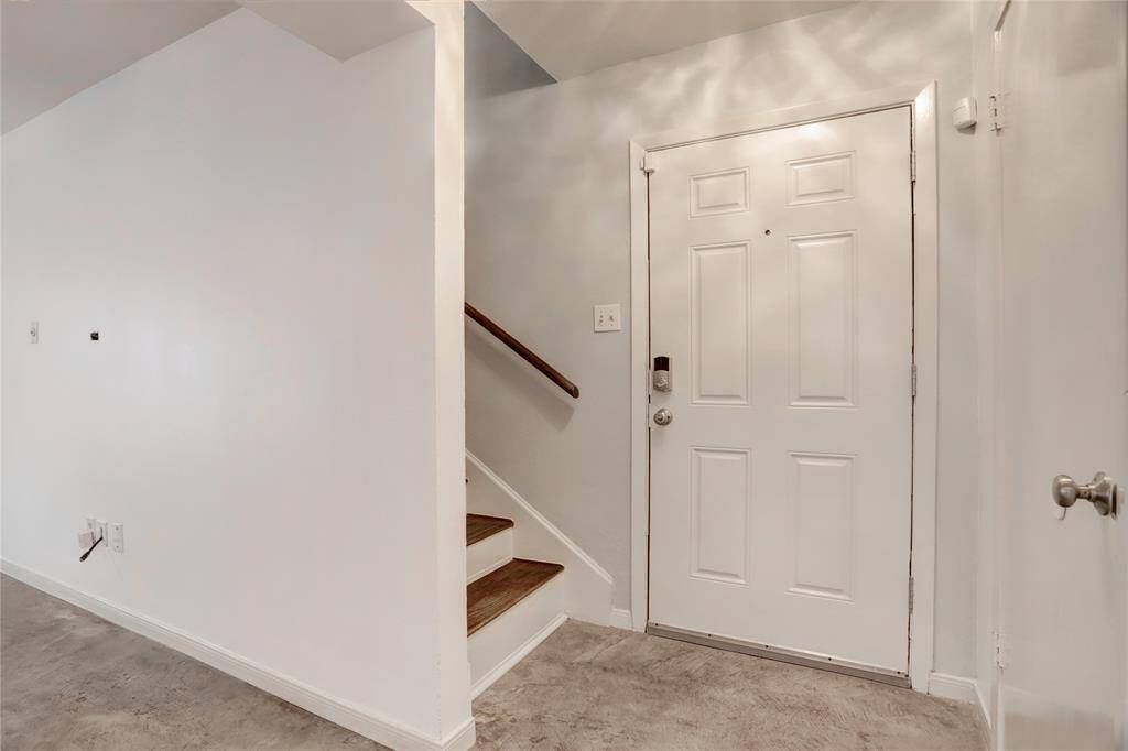 As one gazes upon the front entrance, a set of stairs that take one to the primary bedroom suite come into view.