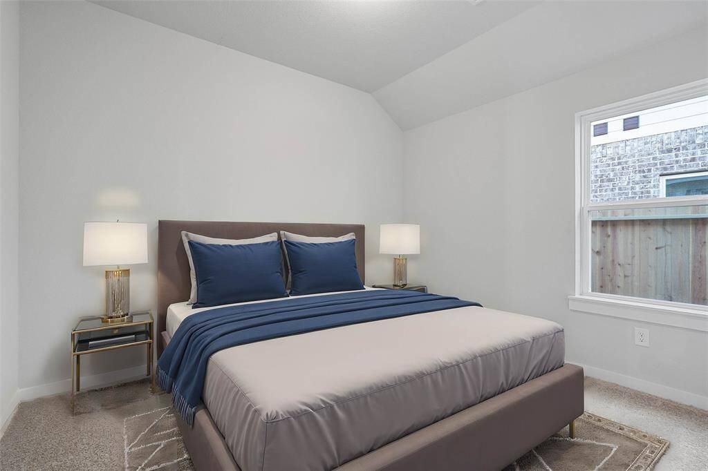 Secondary bedroom features plush carpet, custom paint, lighting, and a large window.