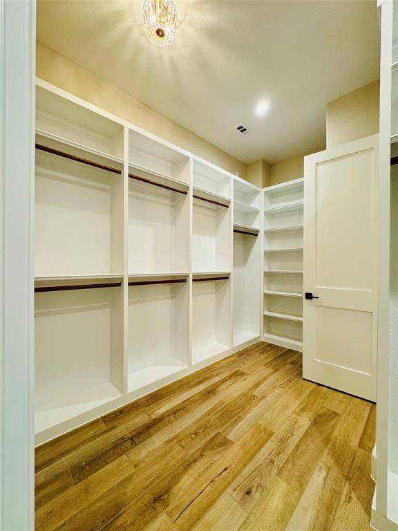 Hers closet with floor to ceiling built ins for maximum storage