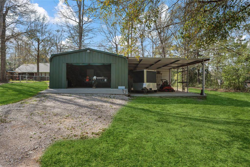 This photo showcases a spacious backyard with a green metal outbuilding, featuring a garage (20x40) and a covered area (20x30) for all your toys or tools.