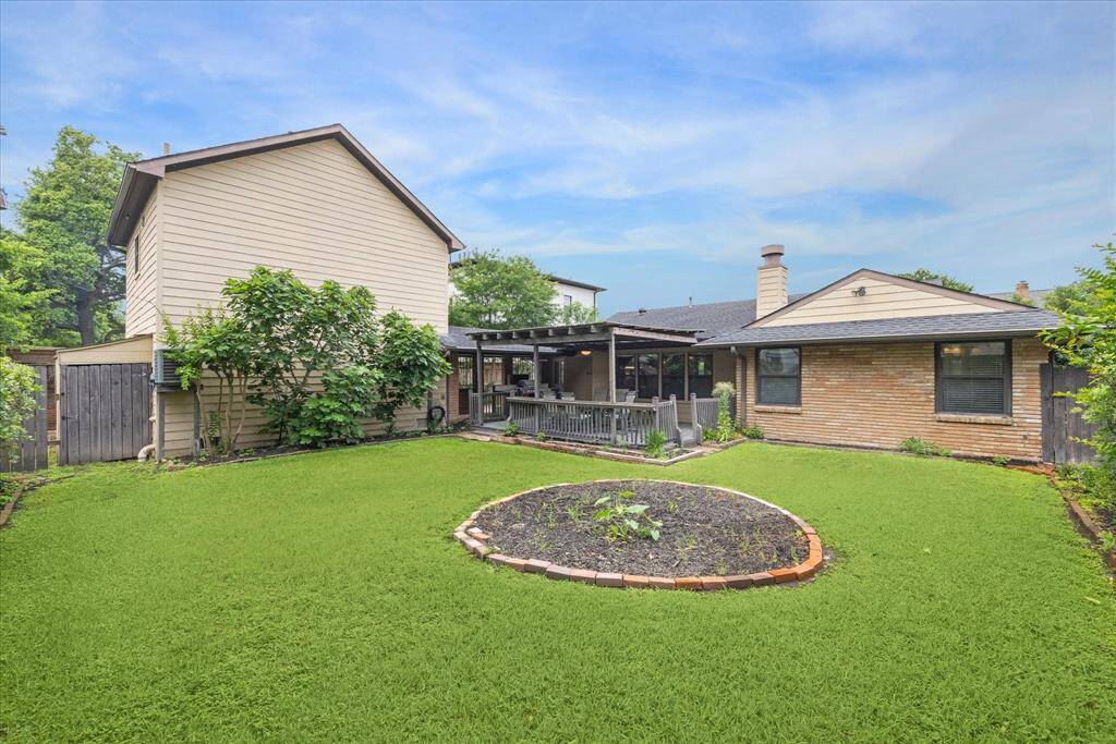 Beautiful fully fenced backyard with view of back of house.