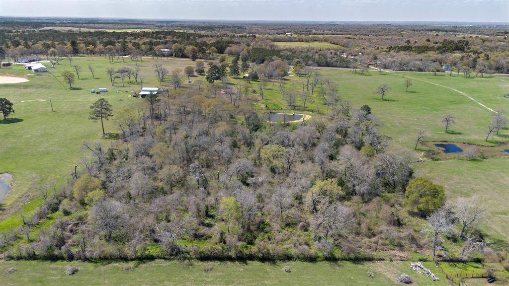 Aerial View of the Wooded Backside of the Property and Pond