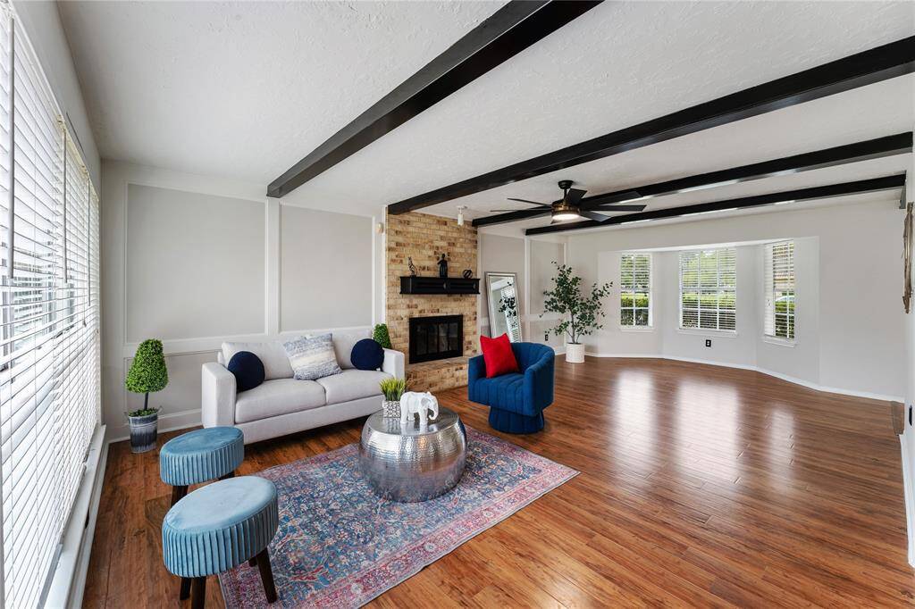 The gorgeous living room, with wood flooring and contrasting fireplace boasts lots of natural light