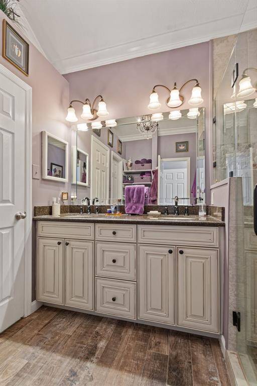 The remodeled primary bath offers updated cabintry, granite counters, attractive (light & plumbing) fixtures, and dual undermount sinks.