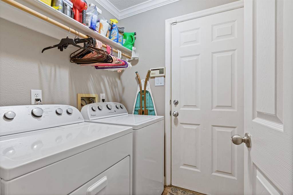 The utility room offers ideal transitional space between the two-car garage and the living spaces. Please note that the washer and dryer stay with the home.