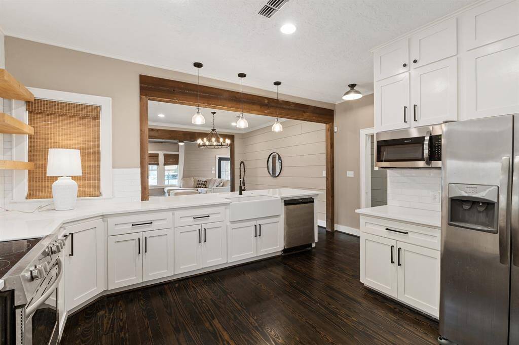 Kitchen looking into dining room. Features quartz counter tops and stainless steel appliances.