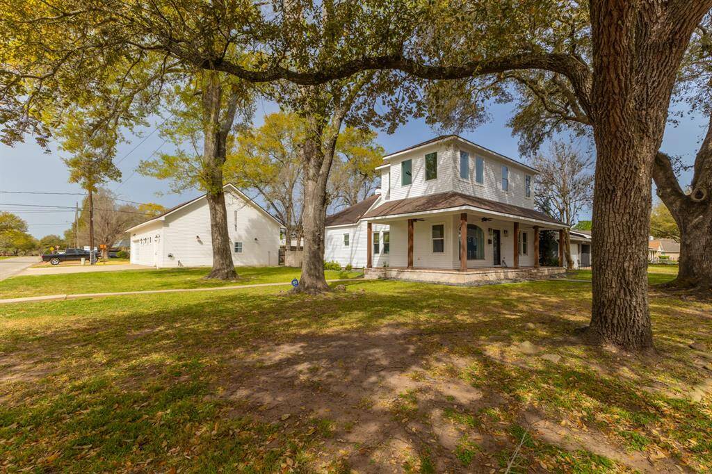 Home features wrap around porch with cedar posts and beautiful mature oak trees. View is from Hardeman Street