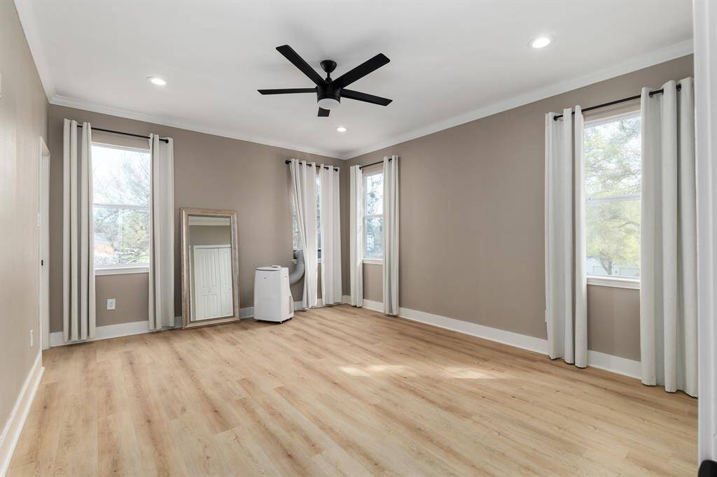 Upstairs master bedroom. Features lots of windows for an open airy feel but also included are black out curtains. Owners primarily used this room and liked to keep the temp at 68 in the summer, so the small portable AC was used for keeping it extra cold.