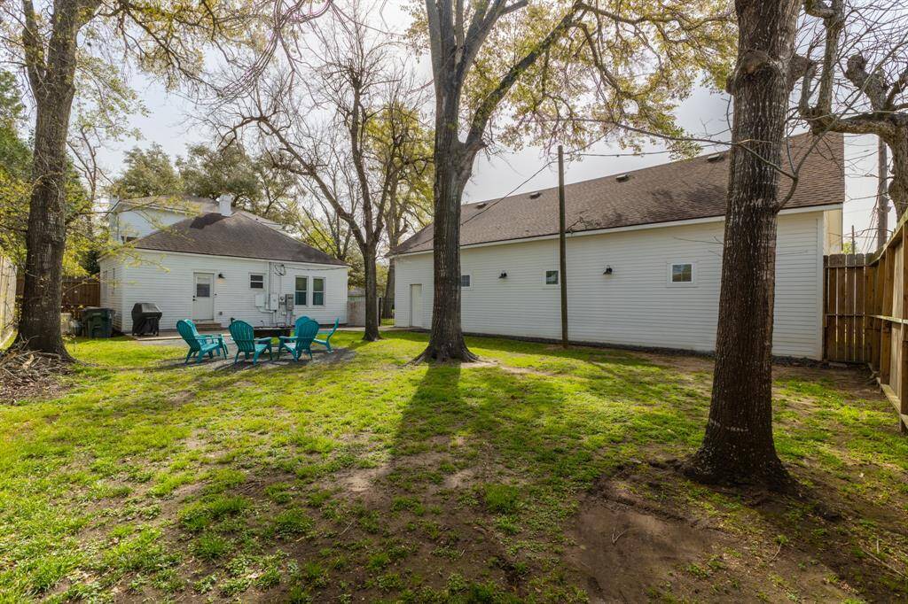 Backyard view looking from back 8 ft tall privacy fence. The whole home generator is to the left of the house, hidden between the house and the privacy fence.