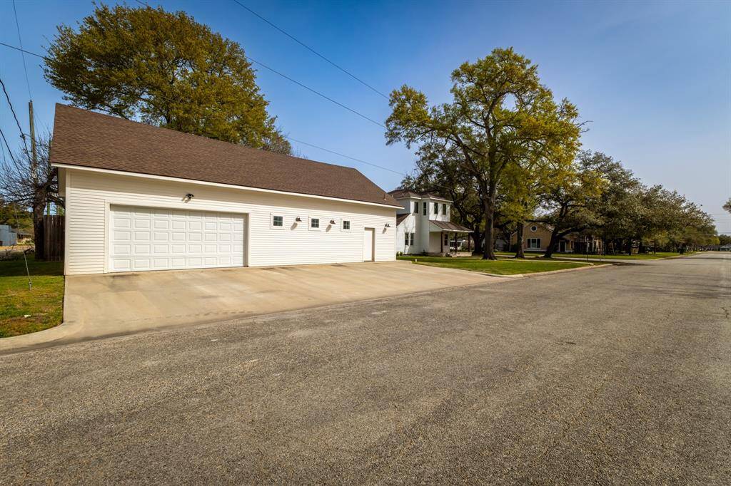 Large garage / shop / workout room / guest suite that features a 1/2 bath and is fully sheet rocked. View is from 6th Street