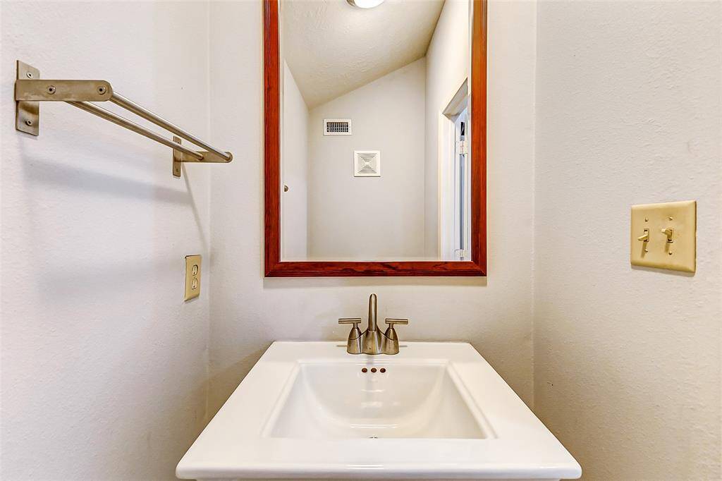 Located next to the living room isa powder bath that includes awhite pedestal sink and brushednickel fixtures.