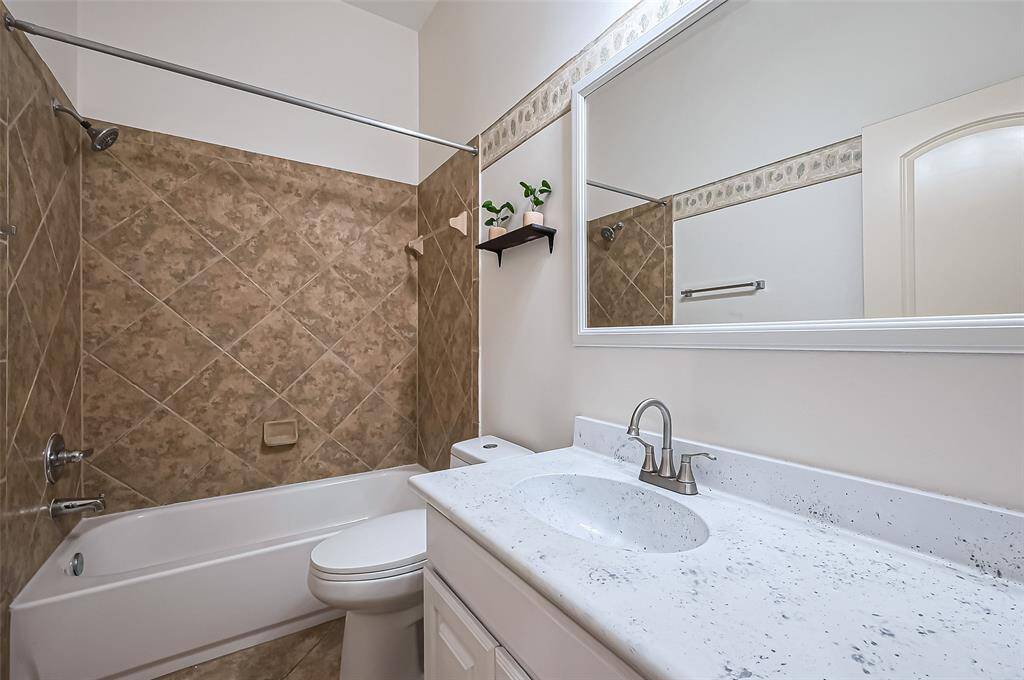 Secondary bathroom with a fresh epoxy countertop finish and framed vanity mirror to add the perfect touch.