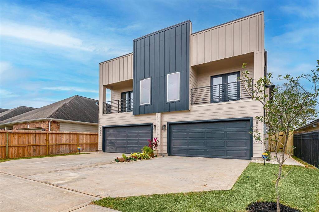 This modern duplex features a sleek façade with vertical siding and contrasting dark panels. It includes two spacious garages, a small landscaped area, and is set in a fenced yard. Ideal for contemporary living with a touch of style.