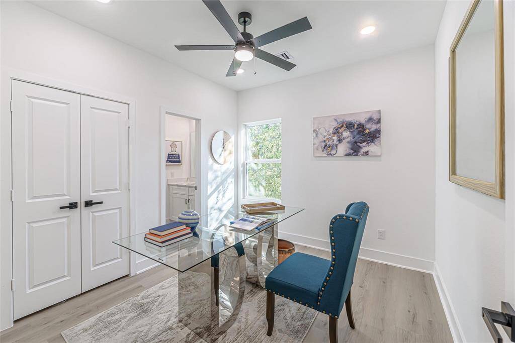 This room can be used as a bright and modern home office. Features a ceiling fan, closet, and natural light from a window.