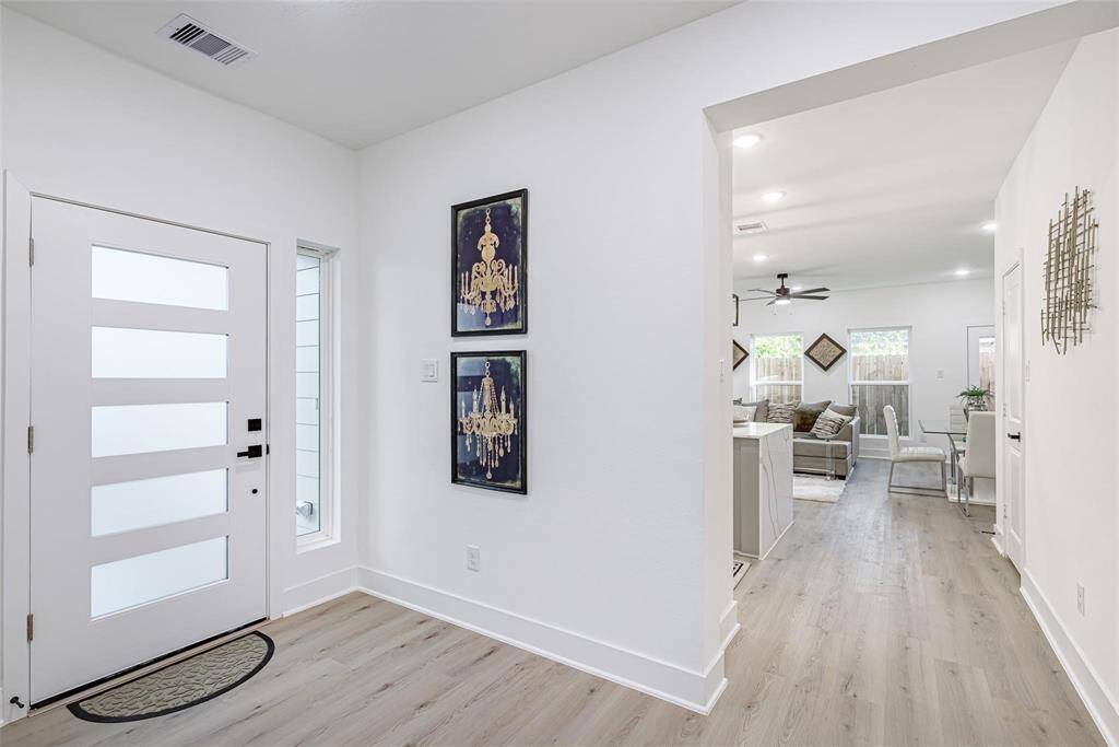 As you enter you are greeted with a contemporary foyer including light wood floors and a sleek, frosted glass entrance door. The open plan opens into a light-filled living space with lots of windows, tasteful furnishings, and neutral décor that creates a cozy ambiance.