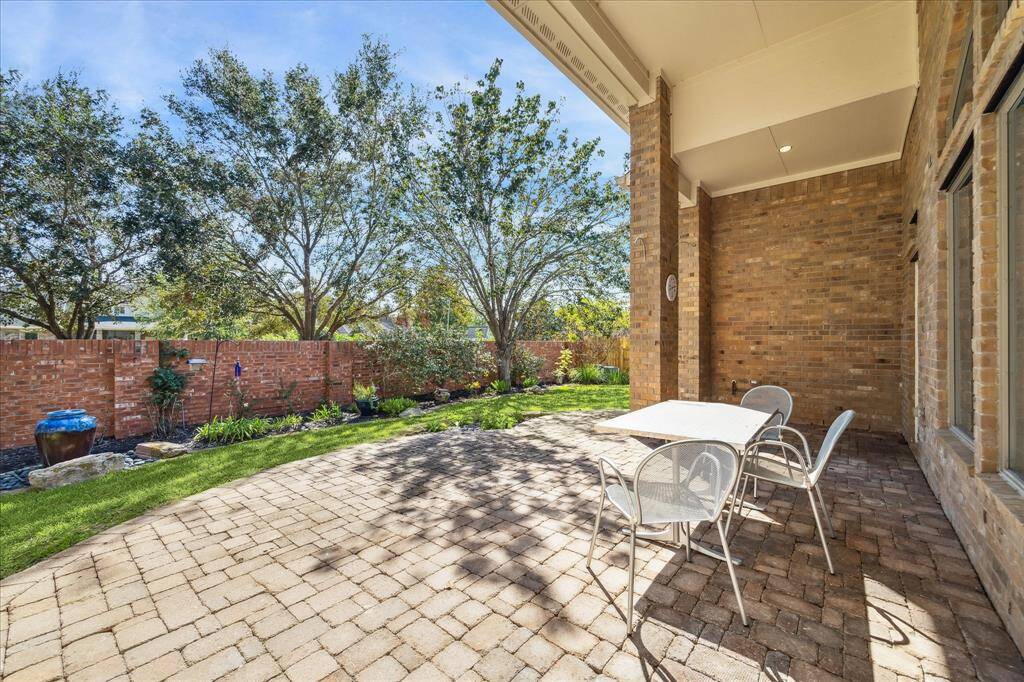 Private covered patio.  Backyard with brick fence.  No back neighbors.  Mature landscaping