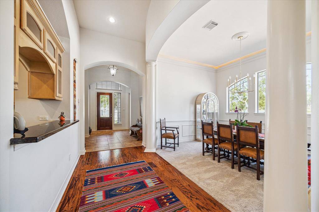 Foyer view of formal dining and kitchen service area