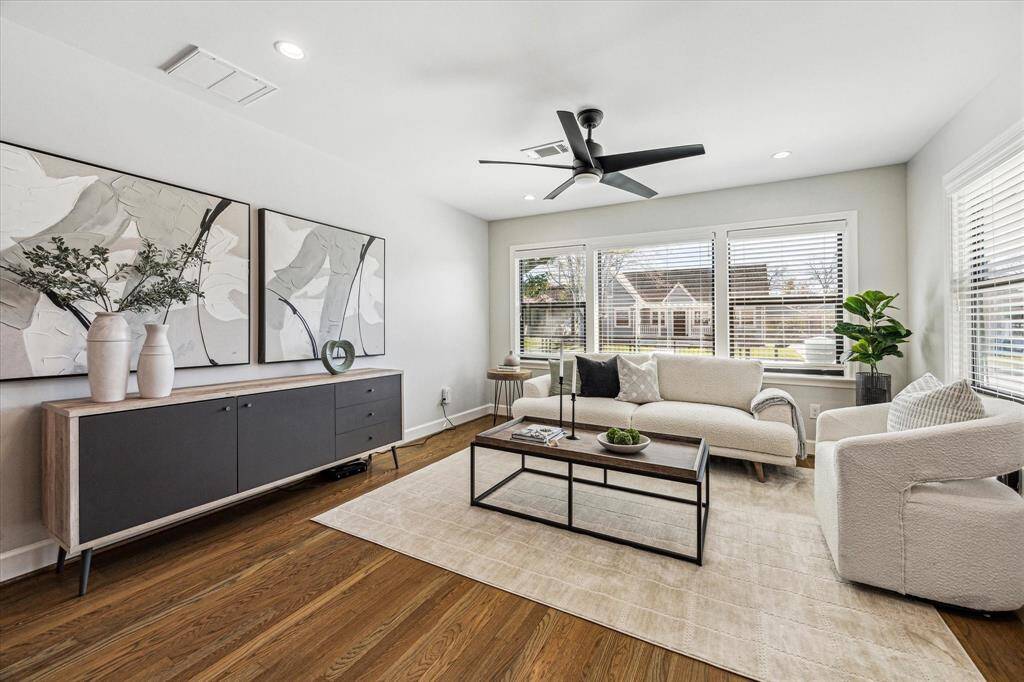 This light and inviting living room is a wonderful space to welcome guests into your home. With stunning hardwood floors, neutral paint, chic lighting and a modern fan, and oversized windows with picture-perfect views.