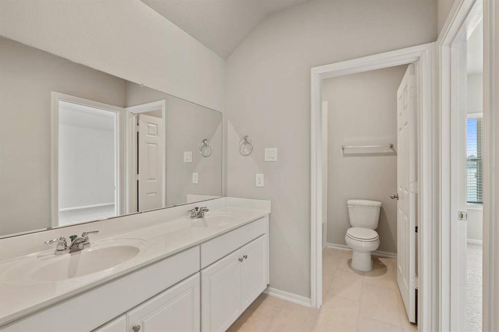 The secondary bath features tile flooring, white cabinetry and light countertops and a shower/tub combo. Perfect for accommodating any visiting family and friends.