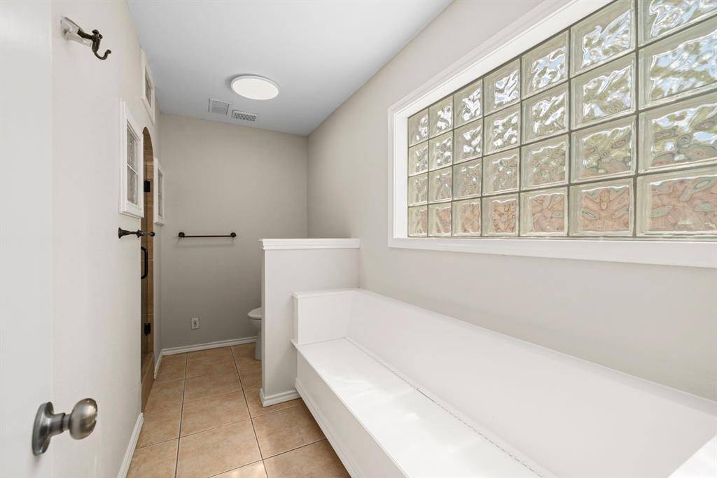 Primary Bath has tiled shower and storage Bench