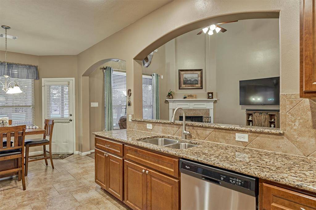 This kitchen features an ideal layout with a conveniently placed sink on the island, perfect for easy dish management without disrupting TV viewing.