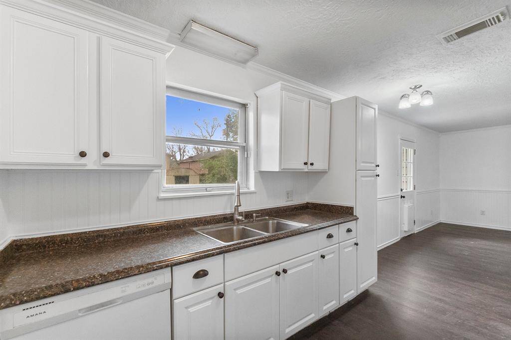 This kitchen is fresh, bright, and totally functional! Clean white cabinets, polished countertops, and a double sink under a big window—so you can soak in the view while you prep. The open layout flows right into the dining and living areas, making it easy to cook, chat, and entertain all in one space.