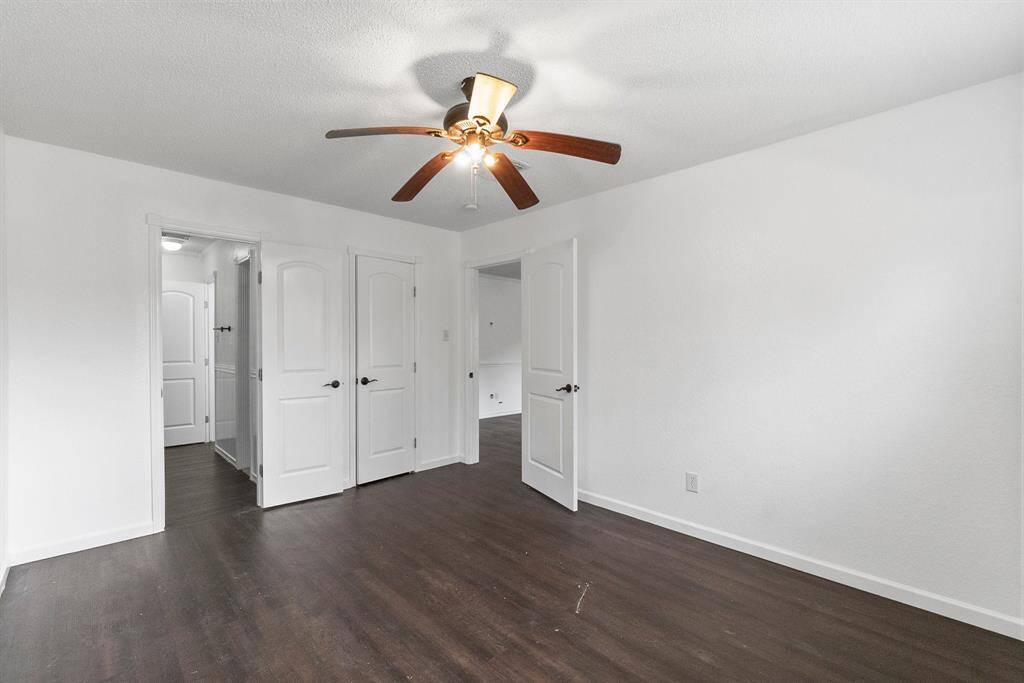 Now this is a bedroom with space to spare! Fresh paint, dark wood-look flooring, and a ceiling fan to keep things comfortable year-round. No fighting over storage here, and the open flow leads right to the rest of the home.