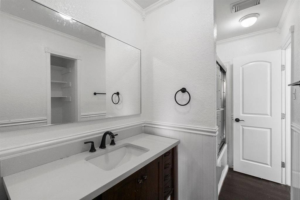 Clean, bright, and totally refreshed! The contrast between the white wainscoting and dark vanity gives this space a classic touch, while built-in shelving and updated fixtures keep it functional. That oversized mirror? Yes.