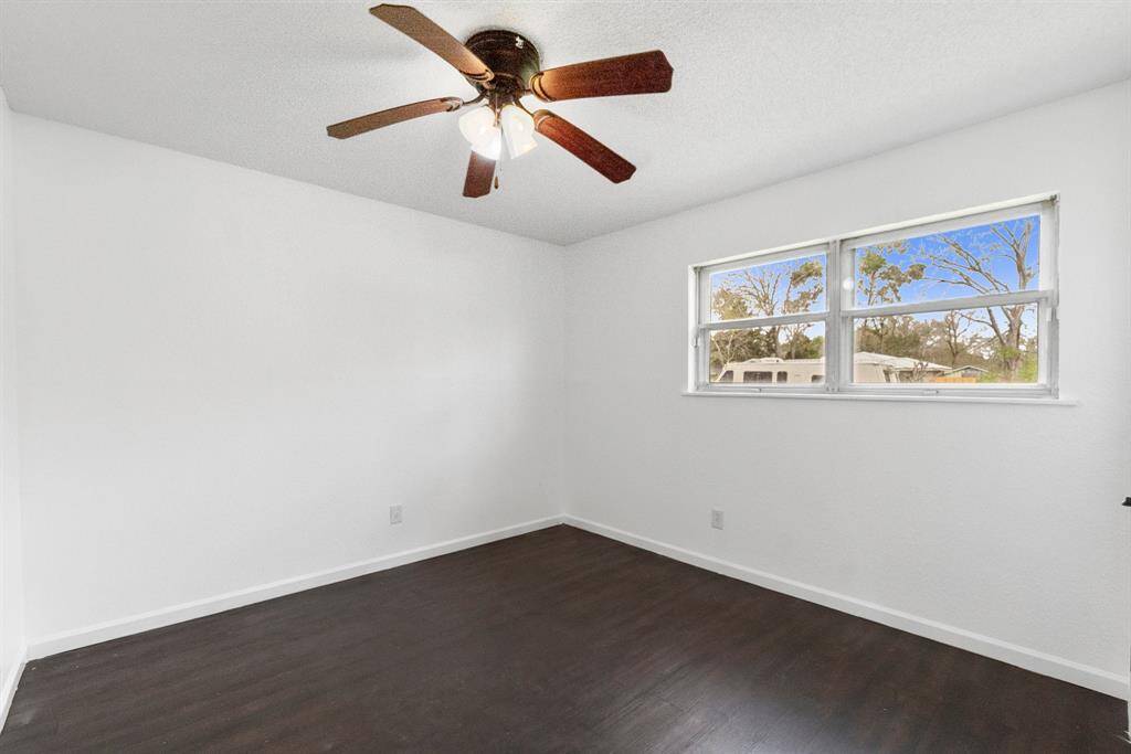 This bedroom has fresh paint, dark wood-look flooring, and a ceiling fan to keep things comfortable. The big window lets in tons of natural light, making the space feel open and airy. Whether it’s a guest room, home office, or a flex room, this space is ready to go.