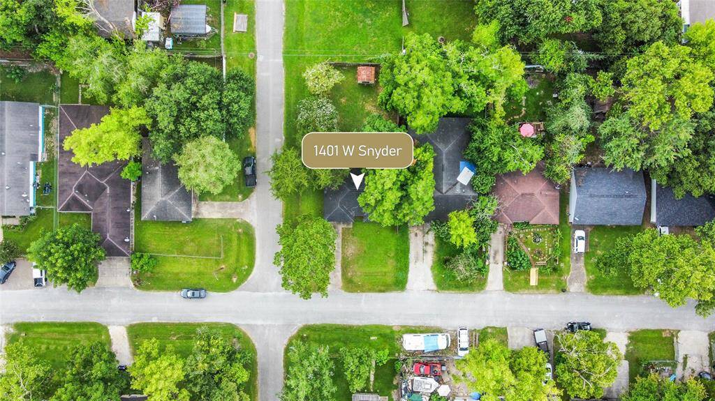 Aerial view showcasing the charming single-story home with its distinct brown brick and beige exterior, perfectly situated on a corner lot.
