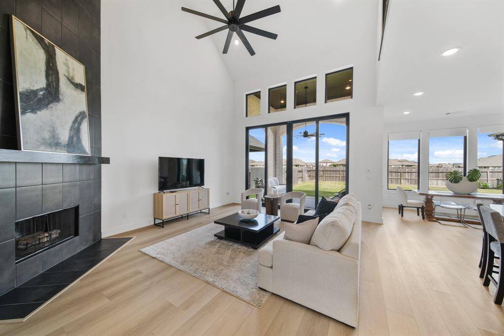 The dramatic family room has a two-story ceiling and a wall of windows. The open concept floor plan is designed with both beauty and function in mind.