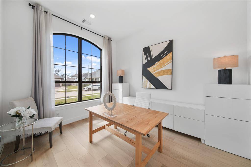 The office has an arched window and recessed lighting, to keep things light and bright.