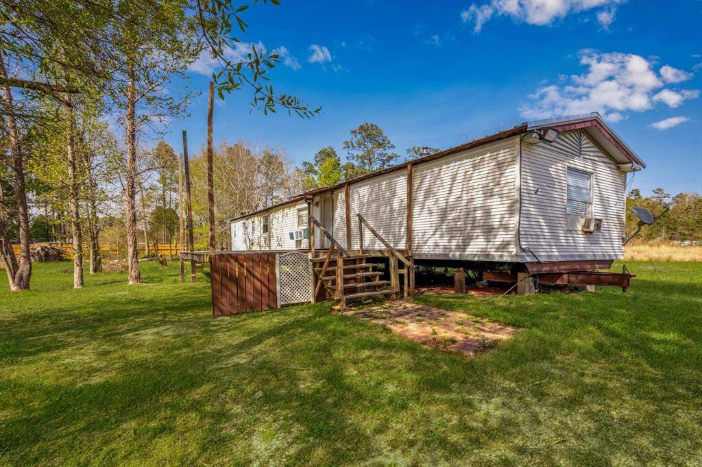 Expansive lot with a cozy mobile home, surrounded by lush greenery and serene views. Perfect for those seeking tranquility and space.