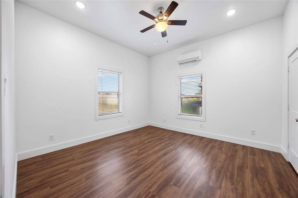The front bedroom offers natural light from two sides of the home. Notice the recessed lighting and the lighted ceiling fan.