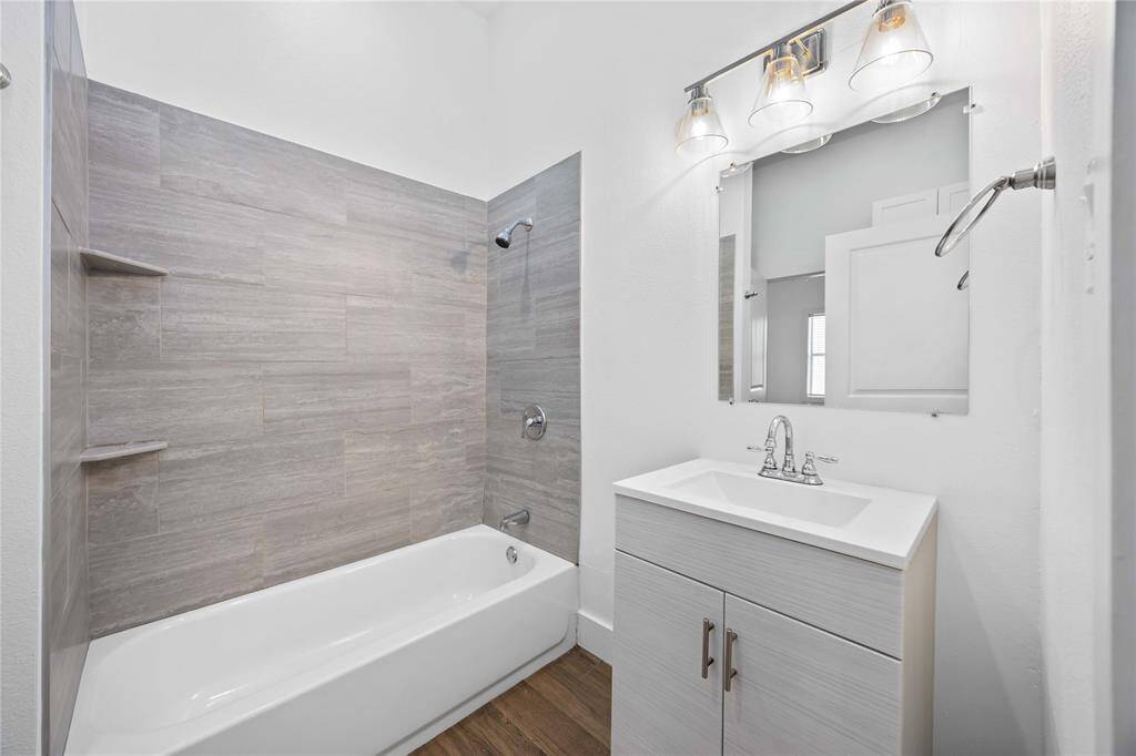 The hall bathroom, accessible from front bedroom or living areas, offers a tub and shower combination with gorgeous tile surround.