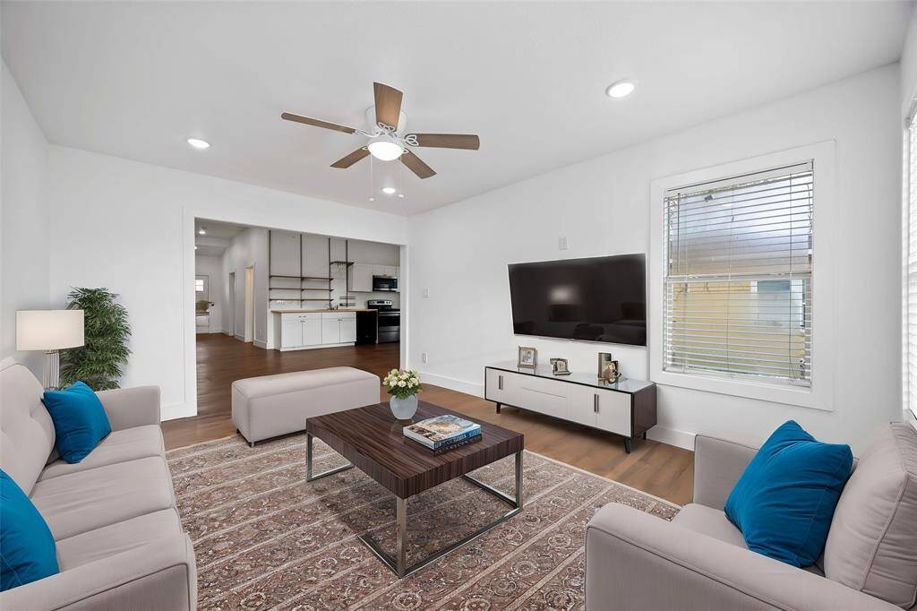 Newly added living room looks into the dining and kitchen. Virtually staged.