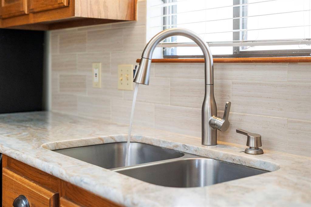 Stainless steel double sink and gooseneck faucet with pull down sprayer.