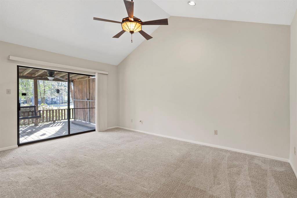 The spacious primary suite boasts a high vaulted ceiling, glass doors to the patio and an en-suite bathroom.