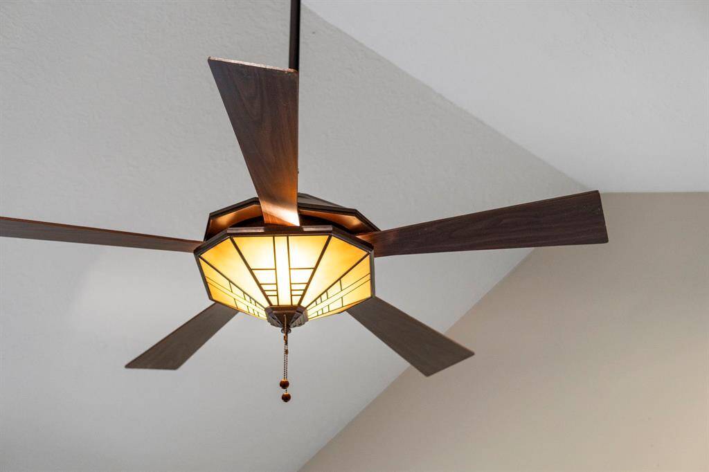 A mission-style lighted ceiling fan illuminates the primary bedroom.