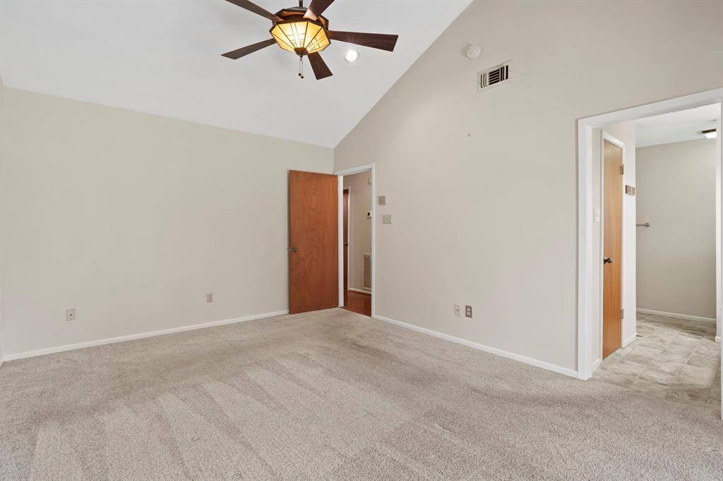 View of the primary bedroom looking toward the entrance to the room and the en suite bathroom.