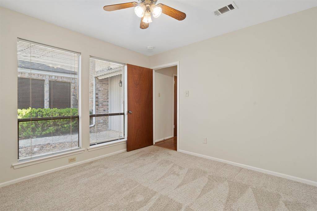 This bedroom has large windows overlooking the front courtyard.