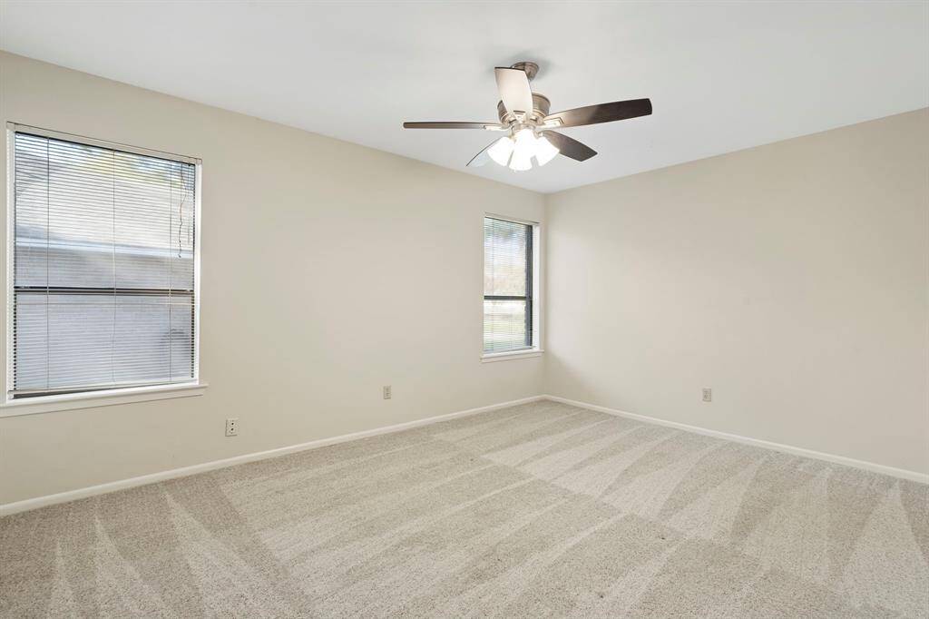 Large windows, neutral paint and light carpet keep secondary bedrooms bright and airy.